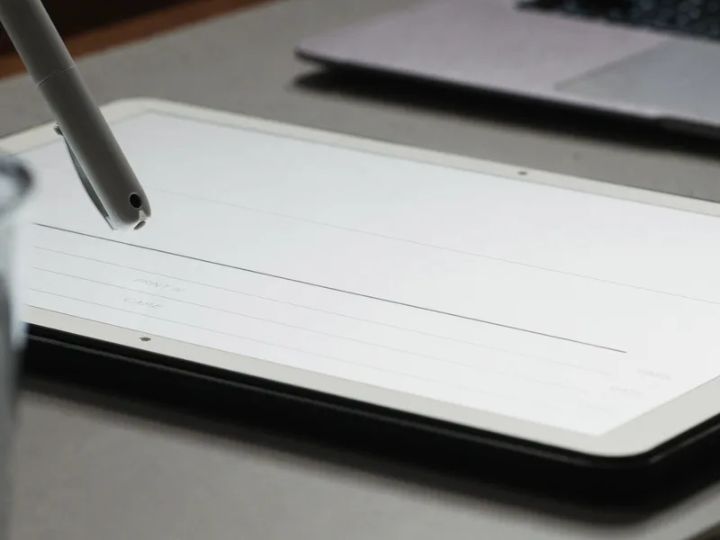 A stylus resting on a tablet showing a signature block